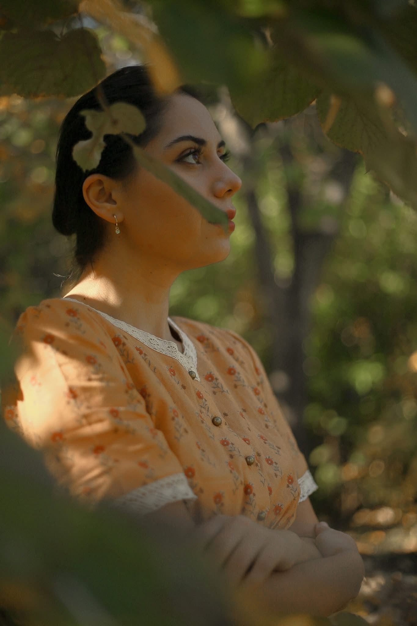Woman in modest nursing dress among green foliage