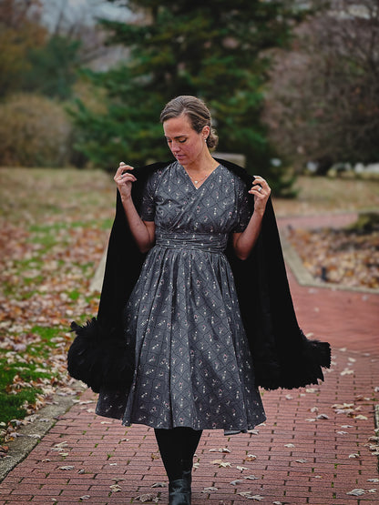 Modest nursing-friendly black dress with cape outdoors