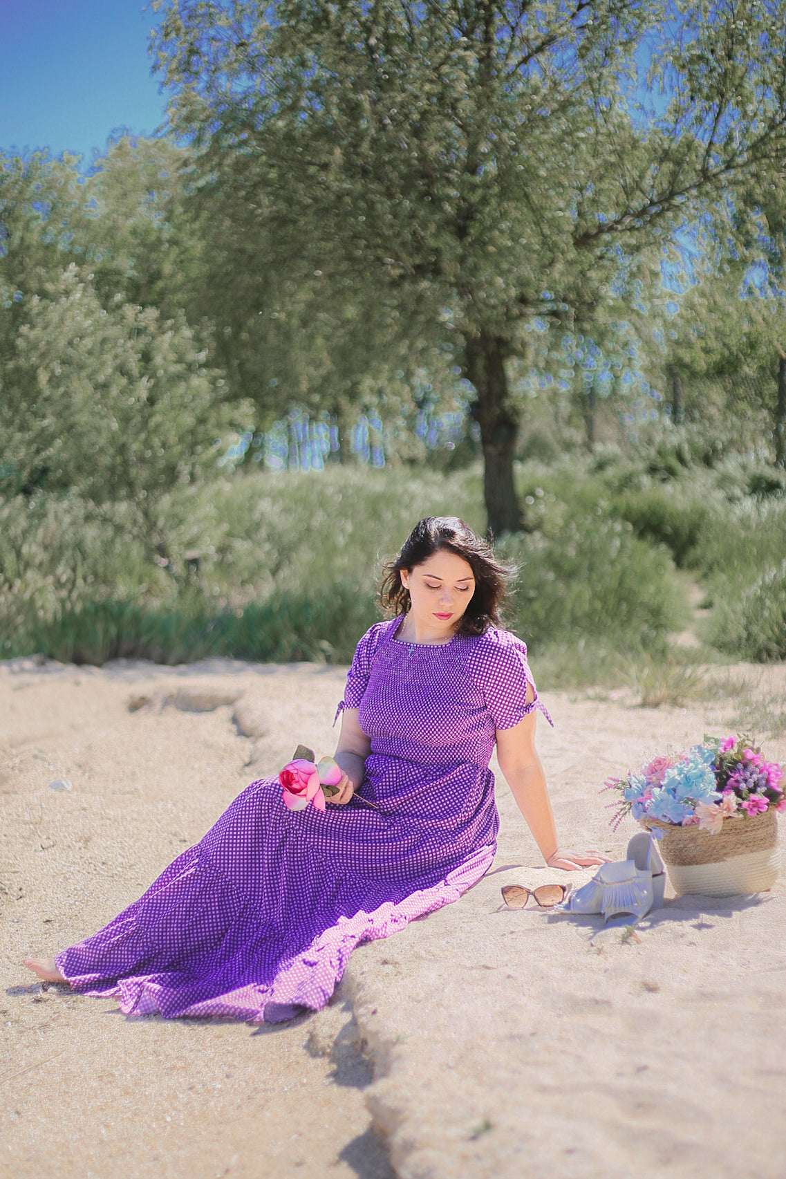 A woman wearing a purple, gingham, five-tiered maxi modest nursing dress