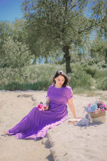 A woman wearing a purple, gingham, five-tiered maxi modest nursing dress