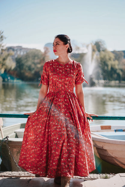 Woman in modest nursing red dress by lake