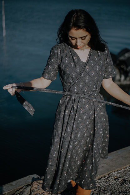 Modest nursing-friendly dark patterned dress by water