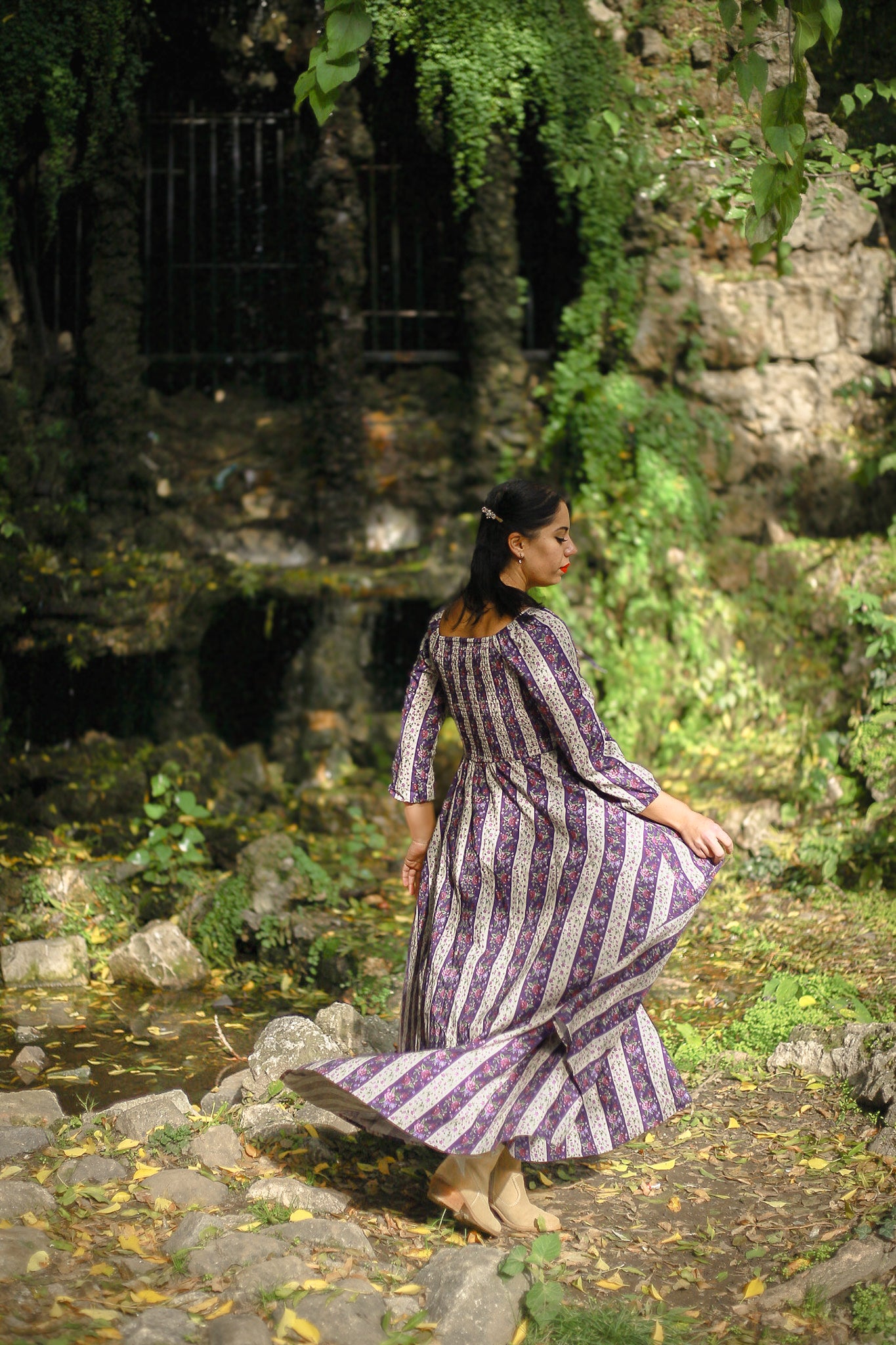 Modest nursing woman in purple striped dress with rocks