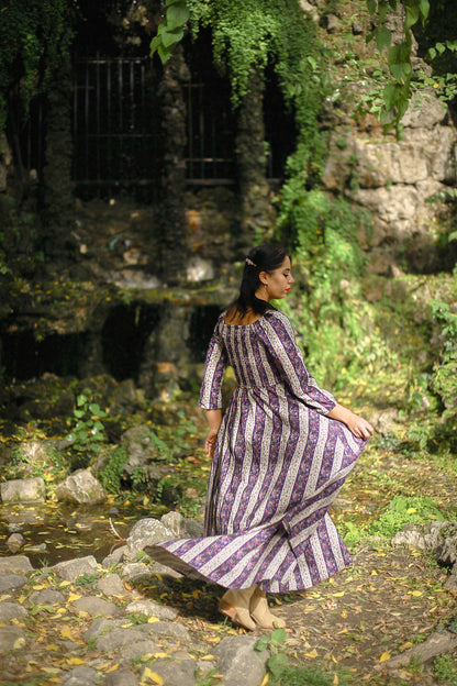 Modest nursing woman in purple striped dress with rocks