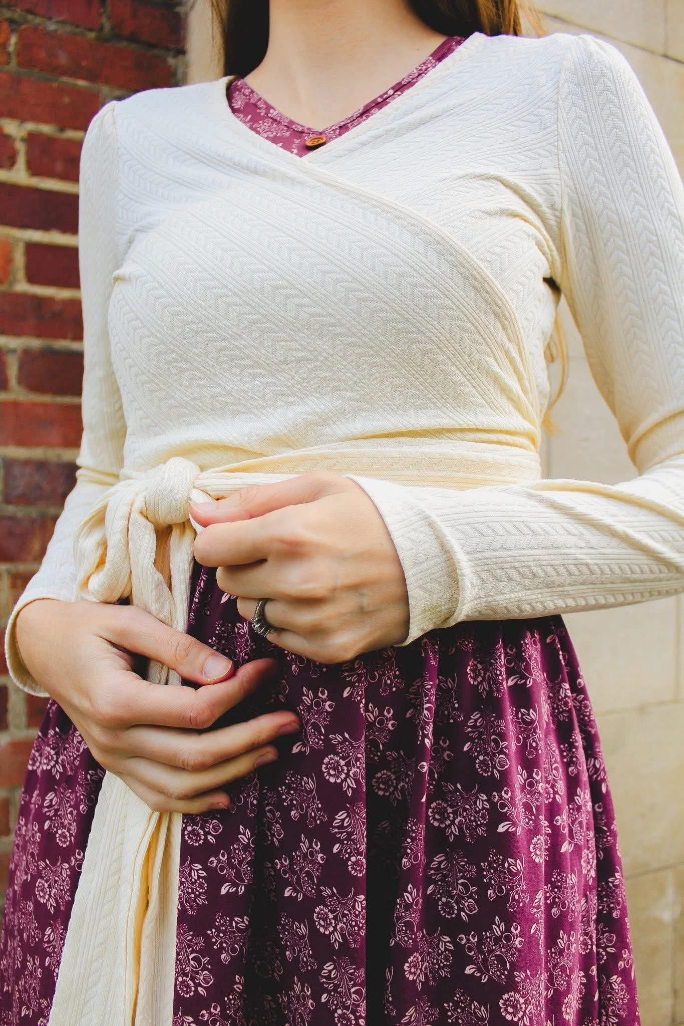 Woman in modest nursing dress against brick wall