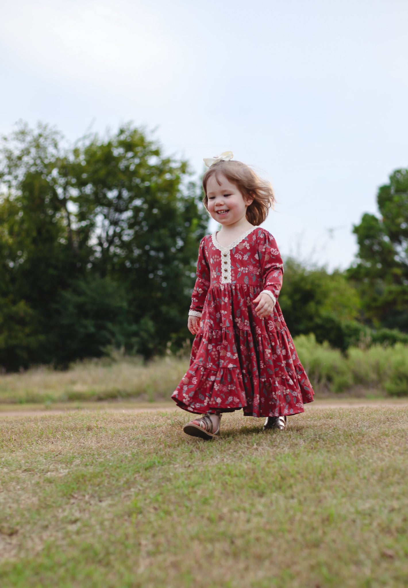 Child in modest red floral dress outdoors