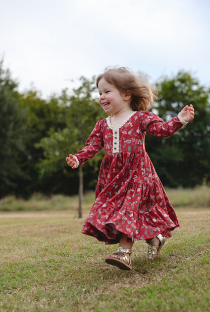 Child in modest red floral dress running outdoors